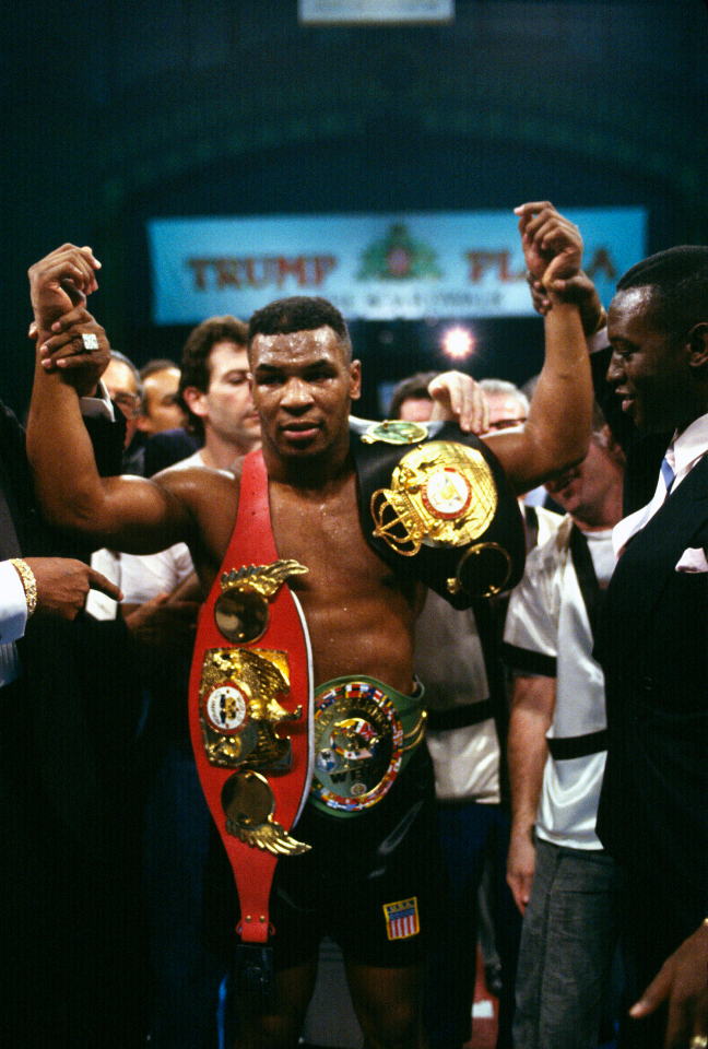 Mike Tyson with championship belts in 1988