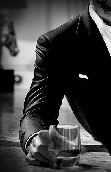 mafia man in black suit with whisky drink