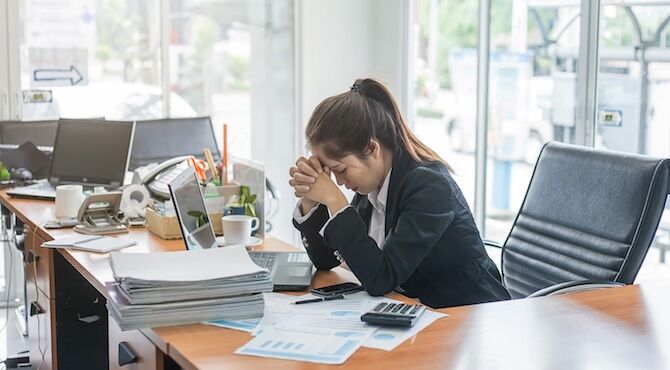 Woman stressed at work desk 